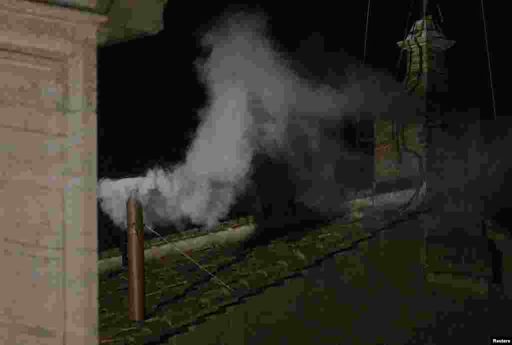White smoke rises from the chimney above the Sistine Chapel in the Vatican, indicating a new pope has been elected.