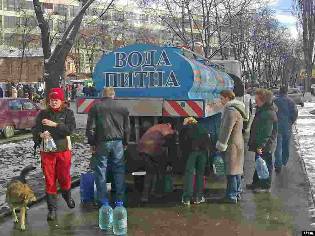 Residents of the Kurenivka district of Kyiv line up for drinking water.