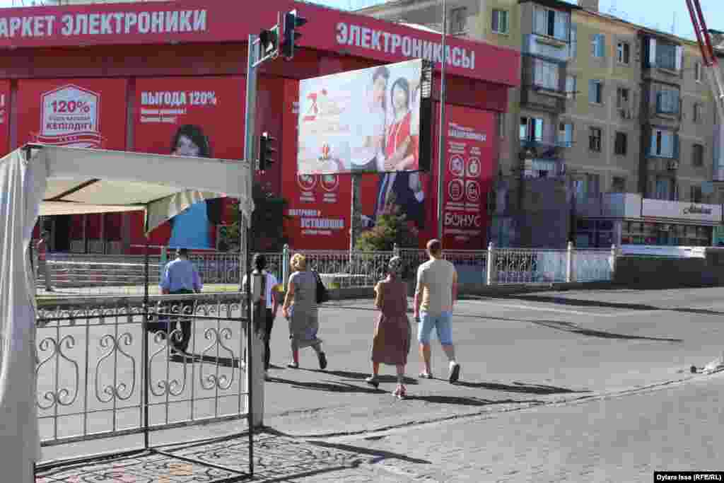 Лас жерасты өткеліне түспеген жолаушылар көлік жолын кесіп өтеді. Шымкент, 16 тамыз 2017 жыл.