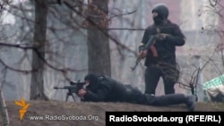 A still photo from RFE/RL Ukrainian Service video (below) showing Ukrainian security forces with a Kalashnikov assault rifle and sniper rifle, respectively, in a confrontation with protesters in Kyiv on February 20, when dozens of Euromaidan supporters were gunned down.