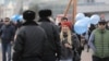 Полицейские направляются к женщине, несущей в руках воздушные шары синего оттенка. Астана, 22 марта 2018 года.