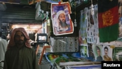 "Әл-Каида" террористік ұйымының өліп қалған көсемі Усама бен Ладеннің суреті Пәкістандағы базарлардың бірінде ілініп тұр.