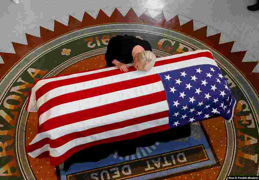 Cindy McCain, wife of longtime U.S. Senator John McCain, touches his casket during a memorial service at the Arizona Capitol in Phoenix. McCain, a Vietnam War hero and former presidential candidate, died on August 25 in his home state from brain cancer at age 81. ((Reuters/Ross D. Franklin/Pool)