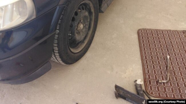 Тожикистон фуқароси машинаси ғилдирагини ечмоқда