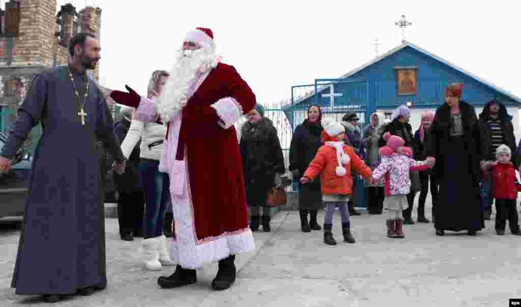 People hold hands during a Christmas celebration after an Orthodox service in the village of Sosnovka, near the Kyrgyz capital, Bishkek.