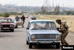 Soldiers from the Ukrainian Azov self-defense battalion check vehicles at a checkpoint in Mariupol. (file photo)