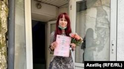 Yelena Gorban shows reporters her wedding certificate on June 23. 