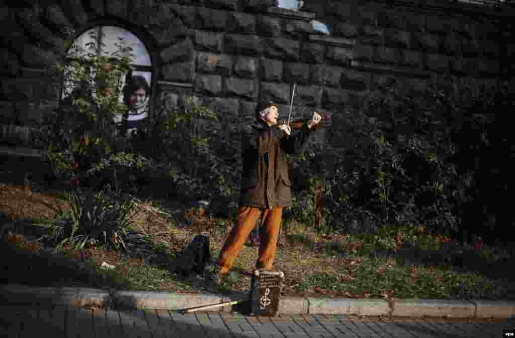 A blind elderly man plays the violin as he tries to drum up some money in downtown Kyiv, Ukraine. (epa/Roman Pilipey)&nbsp;