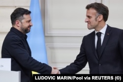 Президент України Володимир Зеленський (ліворуч) потискає руку президенту Франції Емманюелю Макрону (праворуч) після виступу на спільній пресконференції в Парижі, 13 березня 2026 року