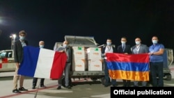 Armenia - Armenian and French officials stand next to the first shipment of coronavirus vaccines donated to Armenia by France, Yerevan, September 14, 2021.