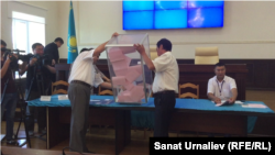 Члены избирательной комиссии выкладывают бюллетени для подсчета голосов. Архивное фото.