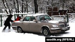 A motorist tries to get a car moving in Tashkent earlier this month.