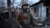 A Ukrainian serviceman stands in the yard of a destroyed house near the line of separation between government forces and separatists near the village of Zolote on February 19. 