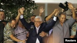 Palestinian President Mahmud Abbas (center) holds hands with Palestinian prisoners who were among the first group to be released from Israeli prisons in August. 