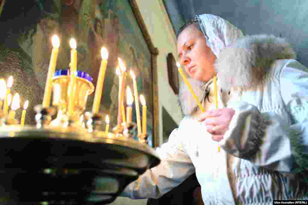 A woman lights a candle at a Christmas Mass in Bishkek, Kyrgyzstan.