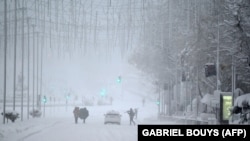 Járókelők a madridi hóesésben 2021. január 9-én