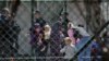 Police officers guard women and children who are relatives of Kosovo Jihadists who returned from Syria, at foreigners detention centre in Pristina, Kosovo, April 20, 2019. REUTERS/Laura Hasani