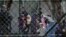 Police officers guard women and children who are relatives of Kosovo Jihadists who returned from Syria, at foreigners detention centre in Pristina, Kosovo, April 20, 2019. REUTERS/Laura Hasani