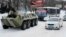 A Ukrainian armored personnel carrier tows a trolleybus behind it on a road covered with snow in Kyiv. (file photo)