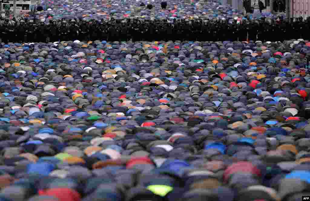 Police stand guard as Muslims pray in a street near the Central Mosque during the Eid al-Adha festival in Moscow. (AFP/Vasily Maximov) 