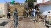 FILE: Afghan security force stand at the site of an attack in Jalalabad.