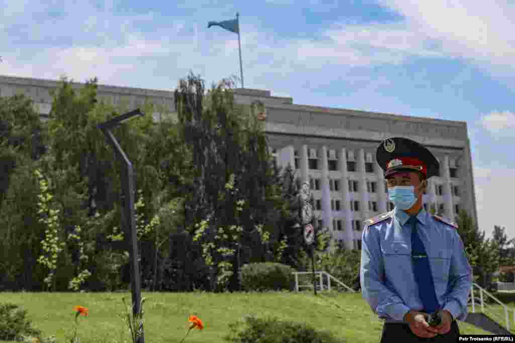 Полицейский дежурит у здания городского акимата, где должен был пройти митинг противников принудительной вакцинации. Алматы, 17 июля 2021 года
