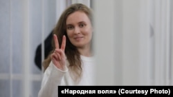 Katsyaryna Andreyeva signals to supporters in the courtroom during her trial in Minsk in February 2021.