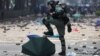 CHINA HONG KONG PROTESTS -- A riot police officer stomps on an umbrella used by pro-democracy protesters during clashes outside the Hong Kong Polytechnic University (PolyU), in Hong Kong, November 18, 2019.