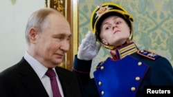 Russian President Vladimir Putin walks past a guard of honor before a meeting with his Belarusian counterpart, Aleksandr Lukashenko, at the Kremlin in Moscow.