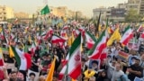 Protestors carry Iranian flags and posters of Supreme Leader Ayatollah Ali Khamenei while chanting anti-US and Israel slogans in Tehran on June 24