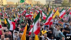 Demonstranti u Teheranu nose iranske zastave i postere vrhovnog vođe ajatolaha Alija Hamneija, uzvikujući slogane protiv SAD i Izraela, 24. jun 2025.