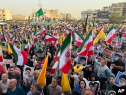 Protestors carry Iranian flags and posters of Supreme Leader Ayatollah Ali Khamenei while chanting anti-US and Israel slogans in Tehran on June 24