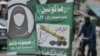 PAKISTAN -- A Pakistani man rides his bicycle past an election poster Sunni Muslim hardliner Tehreek-e-Labbaik Ya Rasool Allah (TLYRA) party depicting a female candidate in black scarf not showing her face, who is contesting for a parliamentary seat in th