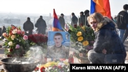 Armenia -- A woman pays respects to a victim of the war over Karabakh, during a gathering for a memorial ceremony, at the Yerablur Military Memorial Cemetery in Yerevan, on December 19, 2020.