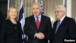 Israeli Prime Minister Binyamin Netanyahu (center) shakes hands with Palestinian Authority President Mahmud Abbas (right) as U.S. Secretary of State Hillary Clinton looks on at Netanyahu's residence in Jerusalem last month.