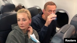 Russian opposition leader Aleksei Navalny and his wife Yulia Navalnaya are seen on board a plane during a flight from Berlin to Moscow on January 17, 2021.