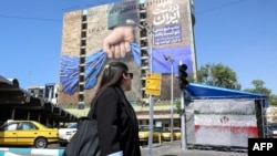 Një grua kalon pranë një bilbordi që i referohet Ngushticës së Hormuzit. Teheran, 15 prill 2026. 