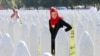 A Bosnian woman searches for her family members as she walks among the grave stones of victims during memorial ceremony last month marking the 31st anniversary of the Srebrenica genocide in Potocari, Bosnia-Herzegovina. 