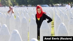 A Bosnian woman searches for her family members as she walks among the grave stones of victims during memorial ceremony last month marking the 31st anniversary of the Srebrenica genocide in Potocari, Bosnia-Herzegovina. 