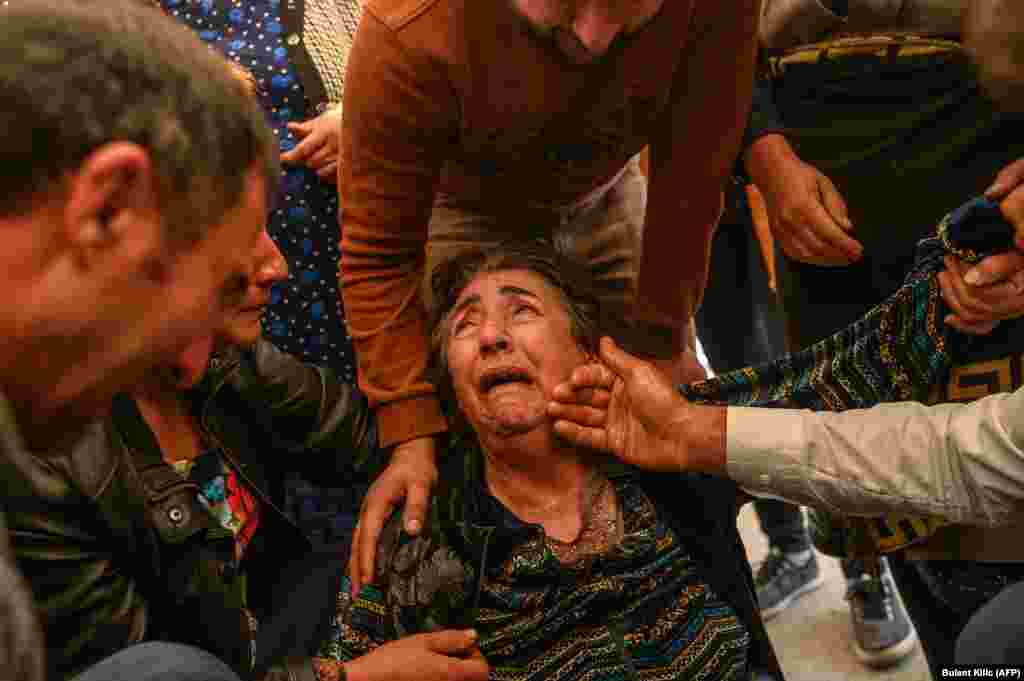 Родичі загиблих Роял Шахназарова, Зулейхи Шахназарової і їхньої дочки Медіне Шахназарової оплакують родину під час похорону 17 жовтня. Вони загинули, коли ракета влучила в їхній будинок в Гянджі (Азербайджан)