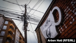 Një shtyllë elektrike pranë një kafeneje në Prishtinë.