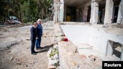 Johann Wadephul și ministrul de Externe al Ucrainei, Andrii Sibiha, depunând flori, pe 25 iunie, la ruinele unei clădiri din Kiev distruse cu o săptămână mai devreme de un atac aerian rusesc care a făcut mai multe victime