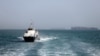 In this picture obtained from Iran's ISNA news agency and taken on May 2, 2026, the Iran-flagged passenger vessel Atlas Pishro cruises near ships anchored in the Strait of Hormuz off Bandar Abbas in southern Iran.