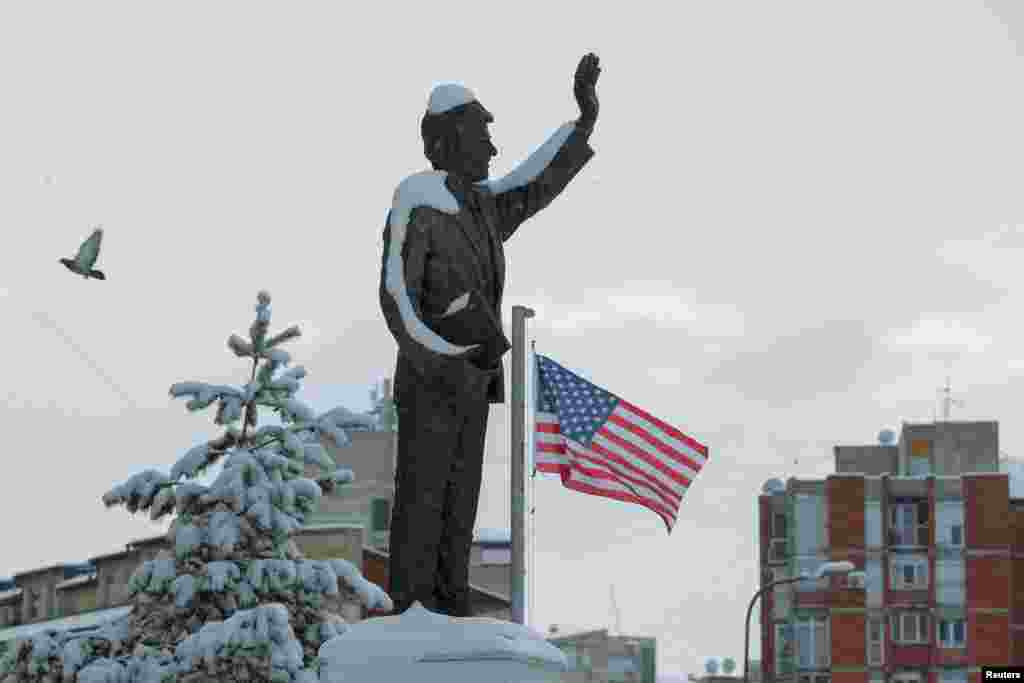 A statue of former U.S. President Bill Clinton is covered by snow at a boulevard named after him in the Kosovar capital, Pristina. 