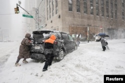 Нью-Йорк шаарындагы Таймс-скверге чукул жерде тыгылып калган машинени түртүп баратышат, 25-январь, 2026-жыл
