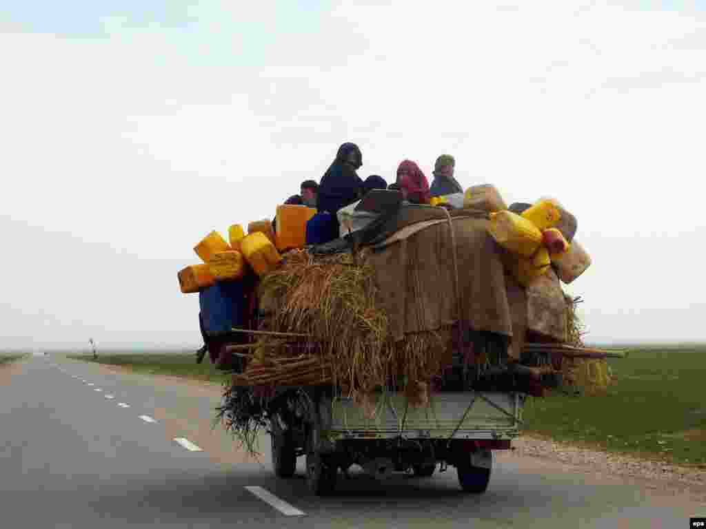 An Afghan family sits atop an overladen vehicle in Konduz. - Afghanistan's Konduz Province, unlike many relatively peaceful provinces in the northern region, has seen an upsurge in Taliban attacks in recent months. Photo by Naqeeb Ahmed for epa