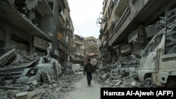 A Syrian child walks down a street past rubble from destroyed buildings in the rebel-held town of Douma in the eastern Ghouta enclave on the outskirts of Damascus earlier this week.