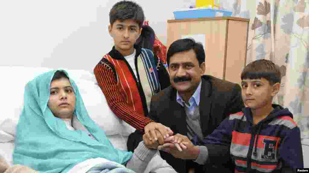 Malala Yousafzai poses with her father, Ziauddin, and her two younger brothers, Khushal Khan and Atal Khan (right), as she recuperates at the the Queen Elizabeth Hospital in Birmingham, England, on October 26, 2012.