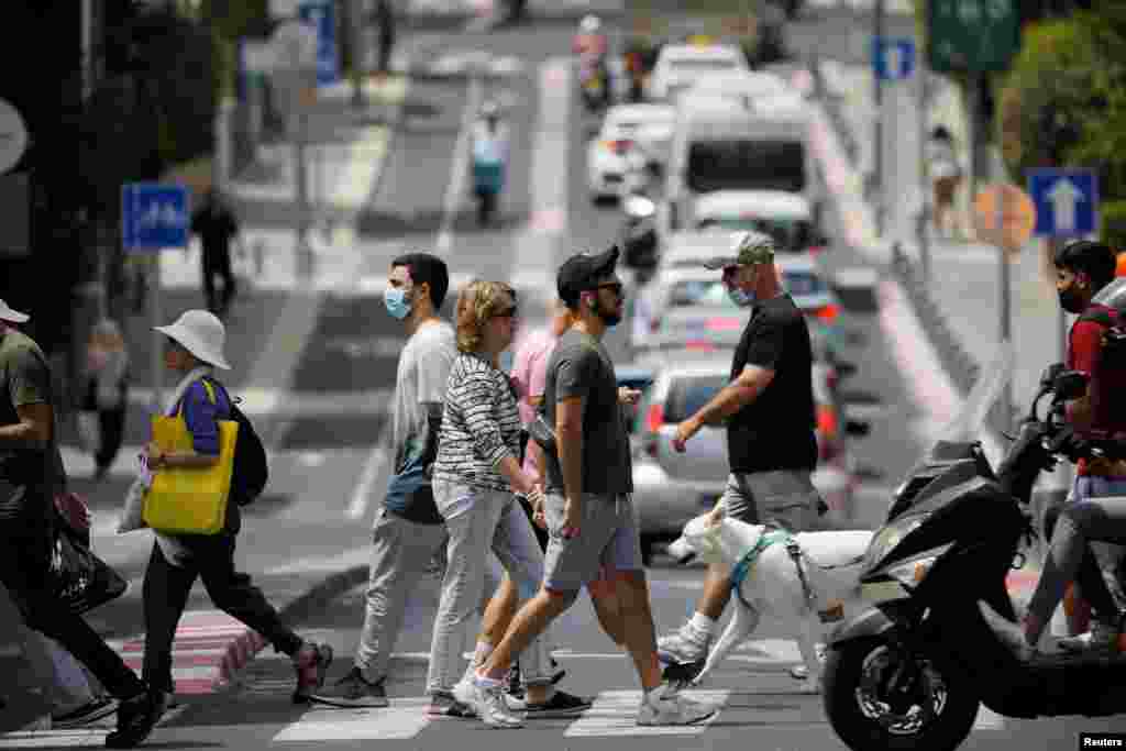 Un tânăr care fie e mai precaut, fie nu a aflat că nu mai este obligat să poarte mască în exterior.&nbsp;REUTERS/Amir Cohen