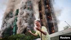 Një burrë reagon pasi tregon se bashkëshortja e tij gjendet brenda kompleksti banesor të përfshirë nga flakët në Hong Kong. 26 nëntor 2025. 